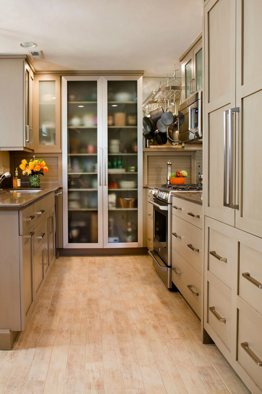 a simple basement galley kitchen with glass-front cabinet