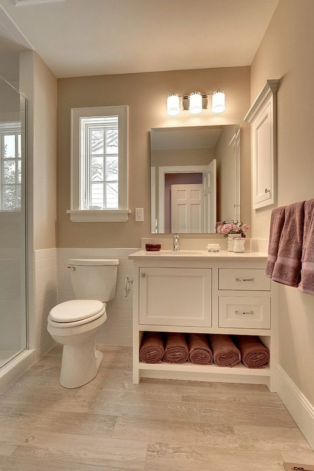 a small bathroom with wood tone floor tile
